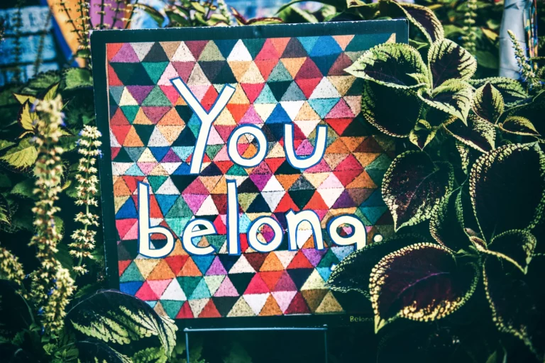 A board featuring the text "You belong" on a background of all kinds of colours